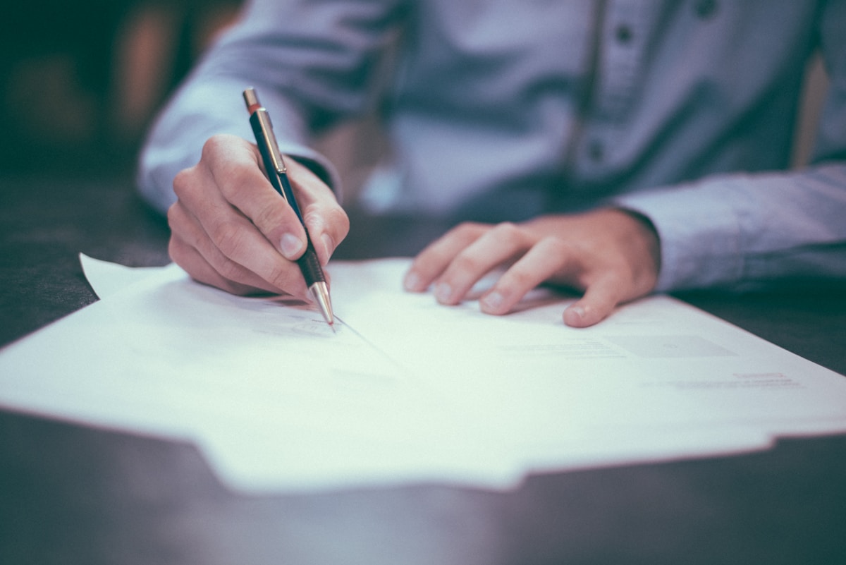 Documents being reviewed and signed at a desk